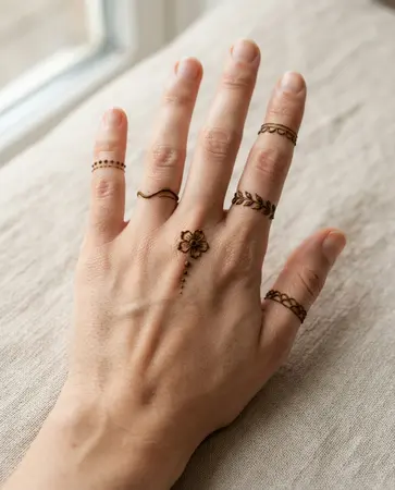 simple back hand mehndi design with thin finger bands and floral accent simple back hand mehndi design with thin finger bands and floral accent