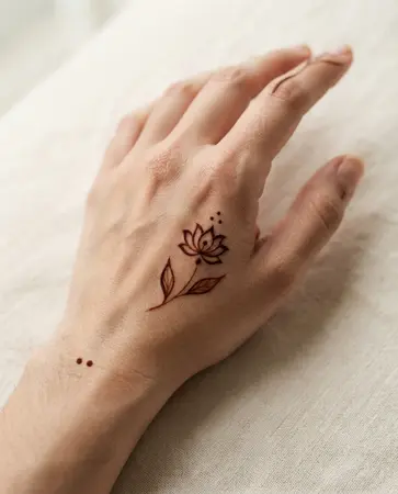 simple back hand mehndi design with a small lotus flower simple back hand mehndi design with a small lotus flower
