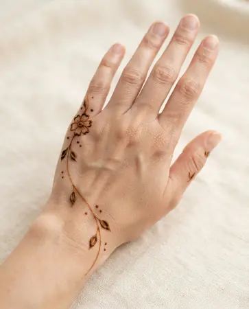 simple back hand mehndi design with flower placed along the hand edge simple back hand mehndi design with flower placed along the hand edge